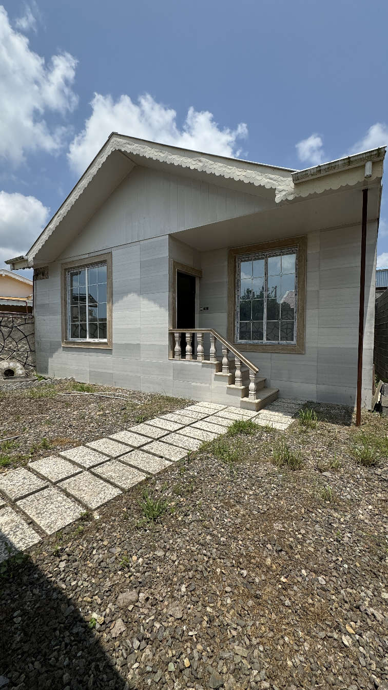 تصویر یک ویلای فلت روستایی که محوطه سازی شده و از چمن مصنوعی استفاده شده