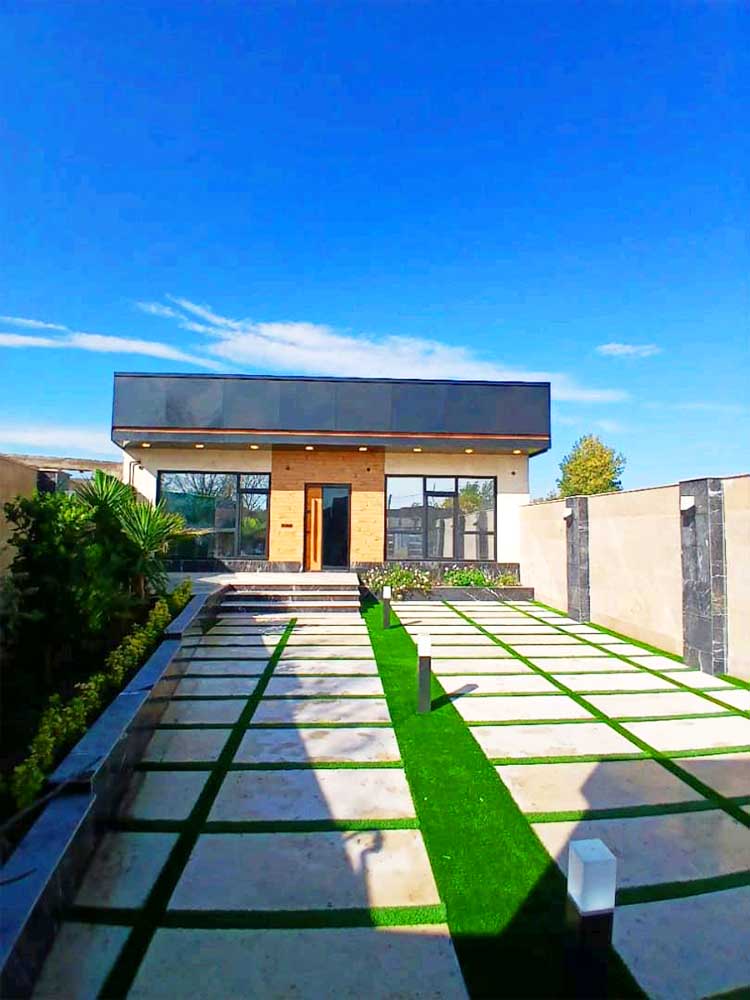 تصویر یک ویلای نما مدرن و محوطه سازی شده با موزاییک و چمن مصنوعی