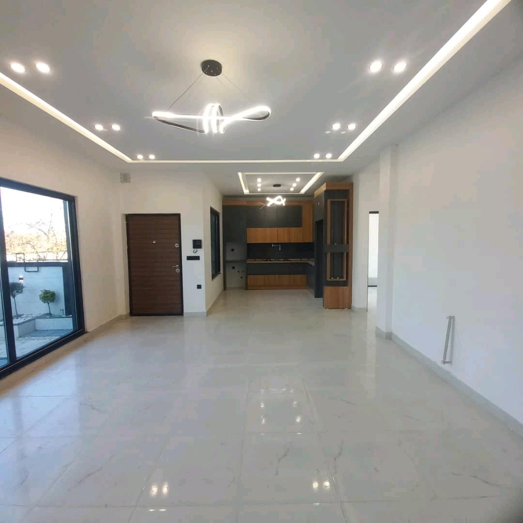 تصویر یک ویلای فلت روستایی که محوطه سازی شده و از چمن مصنوعی استفاده شده