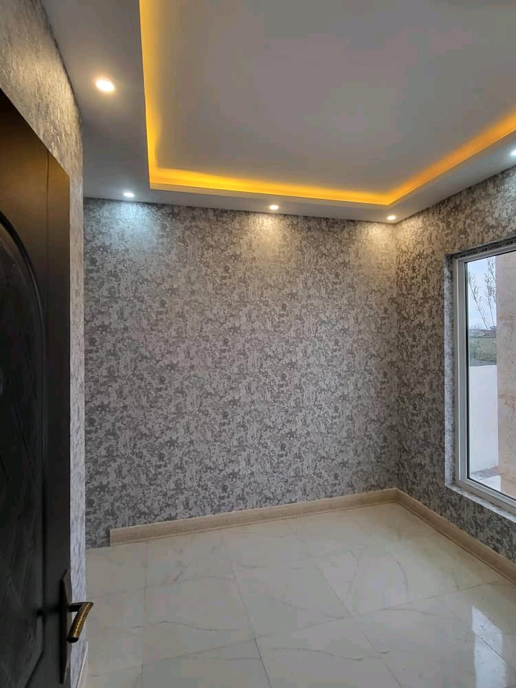 تصویر یک ویلای نما مدرن و محوطه سازی شده با موزاییک و چمن مصنوعی