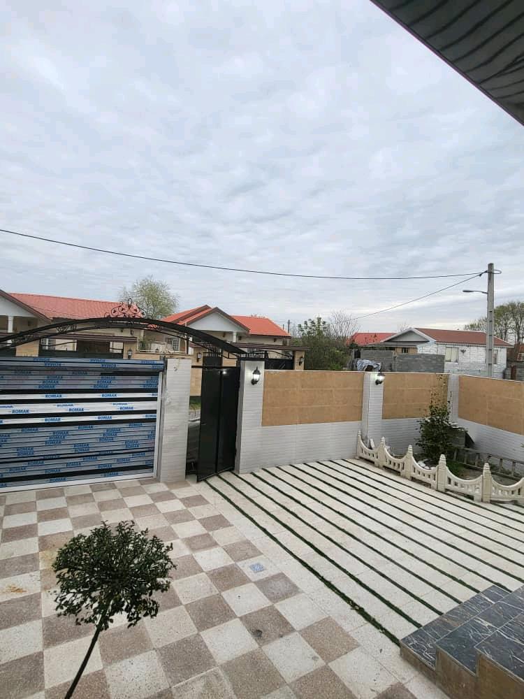 تصویر یک ویلای نما مدرن و محوطه سازی شده با موزاییک و چمن مصنوعی