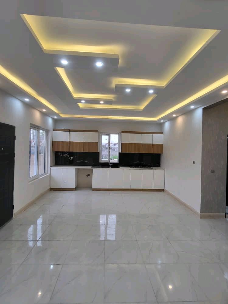 تصویر یک ویلای نما مدرن و محوطه سازی شده با موزاییک و چمن مصنوعی