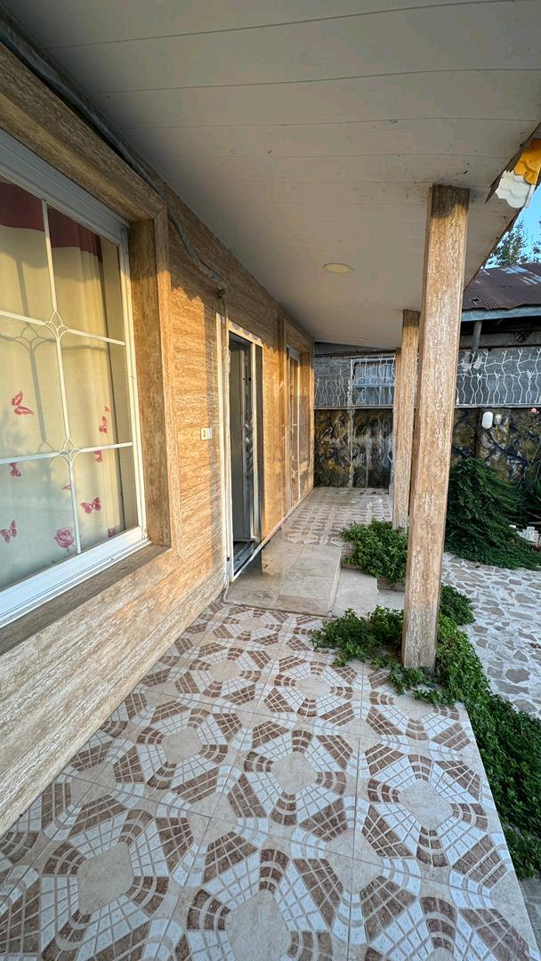 یک ویلای نما سنگ با حیاط بزرگ