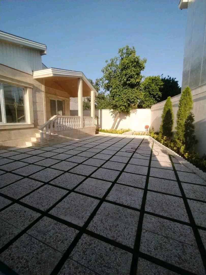 تصویر یک ویلای فلت روستایی که محوطه سازی شده و از چمن مصنوعی استفاده شده