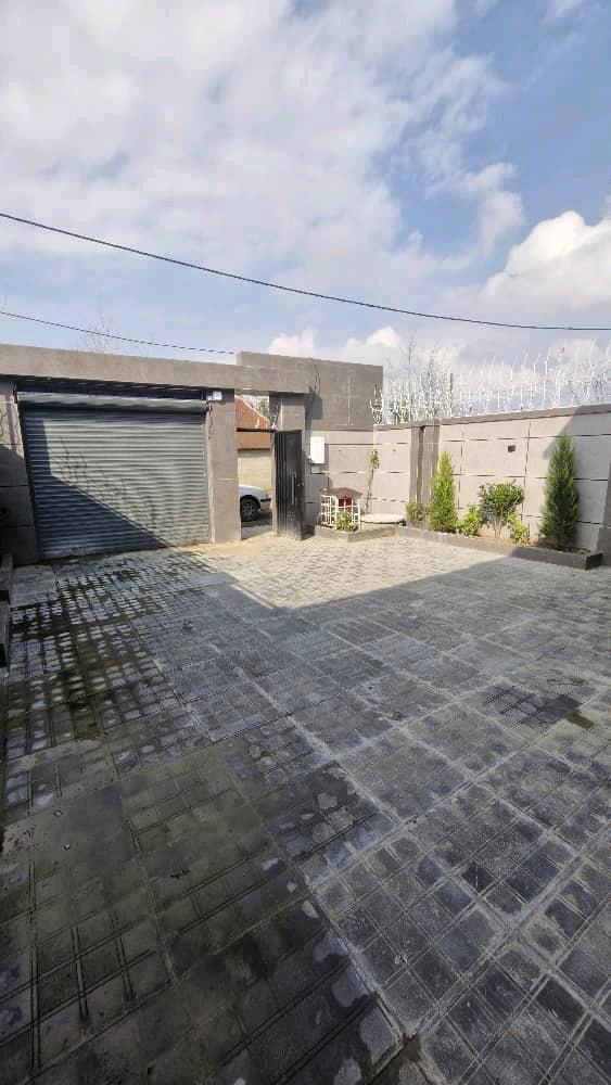 تصویر یک ویلای نما مدرن و محوطه سازی شده با موزاییک و چمن مصنوعی