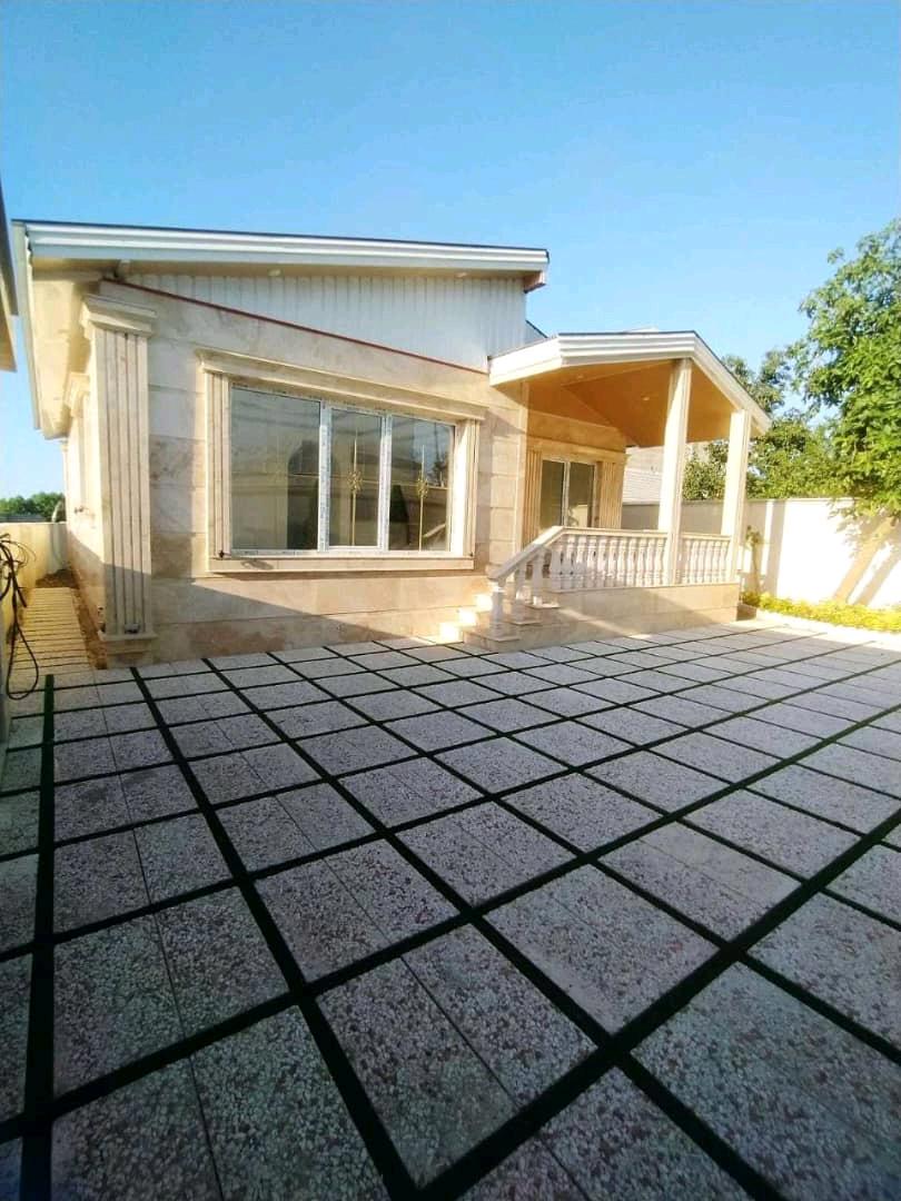 تصویر یک ویلای فلت روستایی که محوطه سازی شده و از چمن مصنوعی استفاده شده