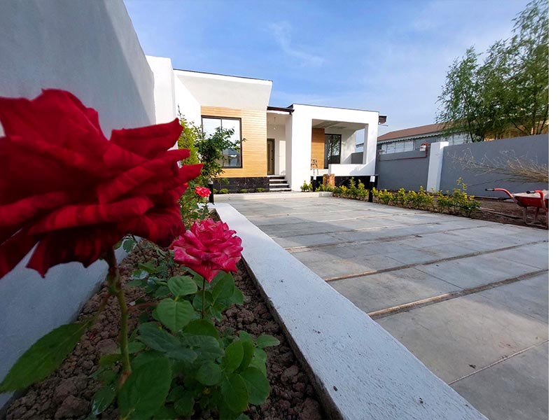 تصویر یک ویلای نما مدرن و محوطه سازی شده با موزاییک و چمن مصنوعی