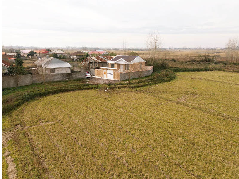 تصویر یک ویلای نما کلاسیک و محوطه سازی شده با موزاییک و چمن مصنوعی