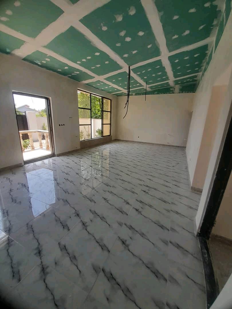 تصویر یک ویلای نما مدرن و محوطه سازی شده با موزاییک و چمن مصنوعی