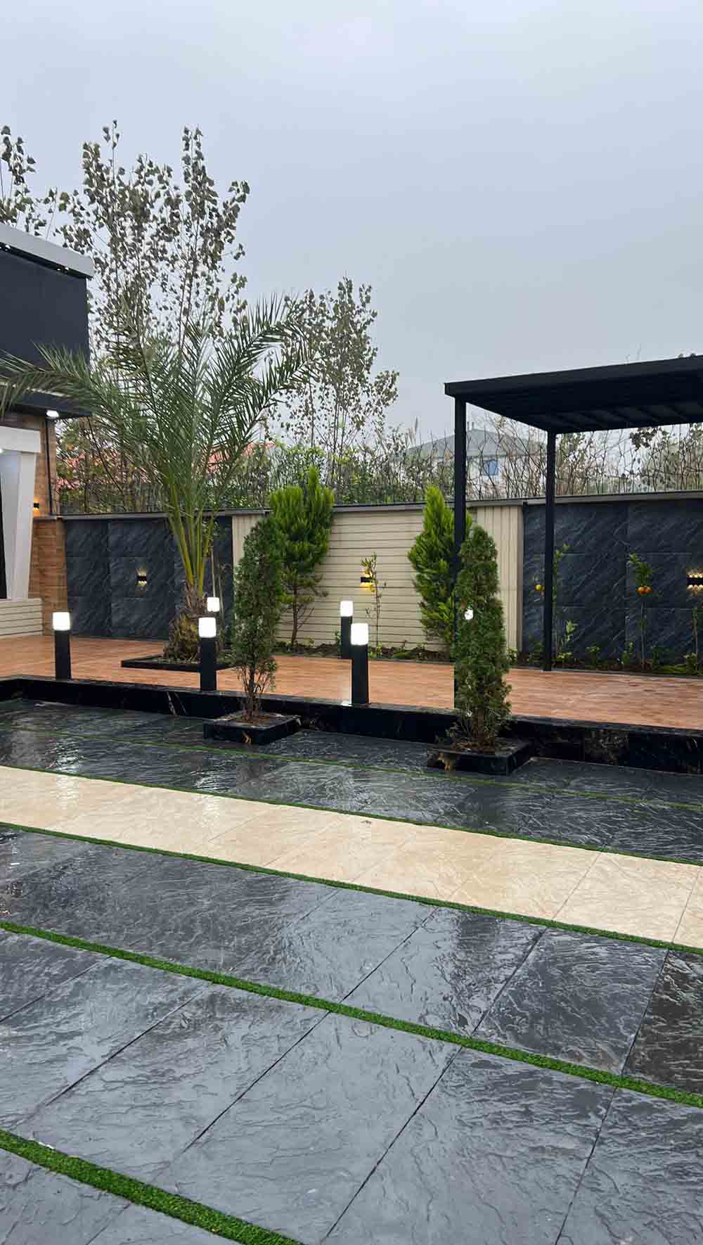 تصویر یک ویلای نما مدرن و محوطه سازی شده با موزاییک و چمن مصنوعی