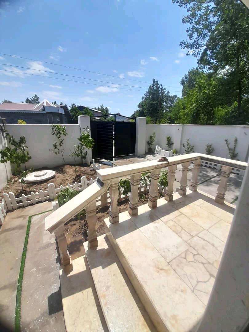 تصویر یک ویلای نما مدرن و محوطه سازی شده با موزاییک و چمن مصنوعی