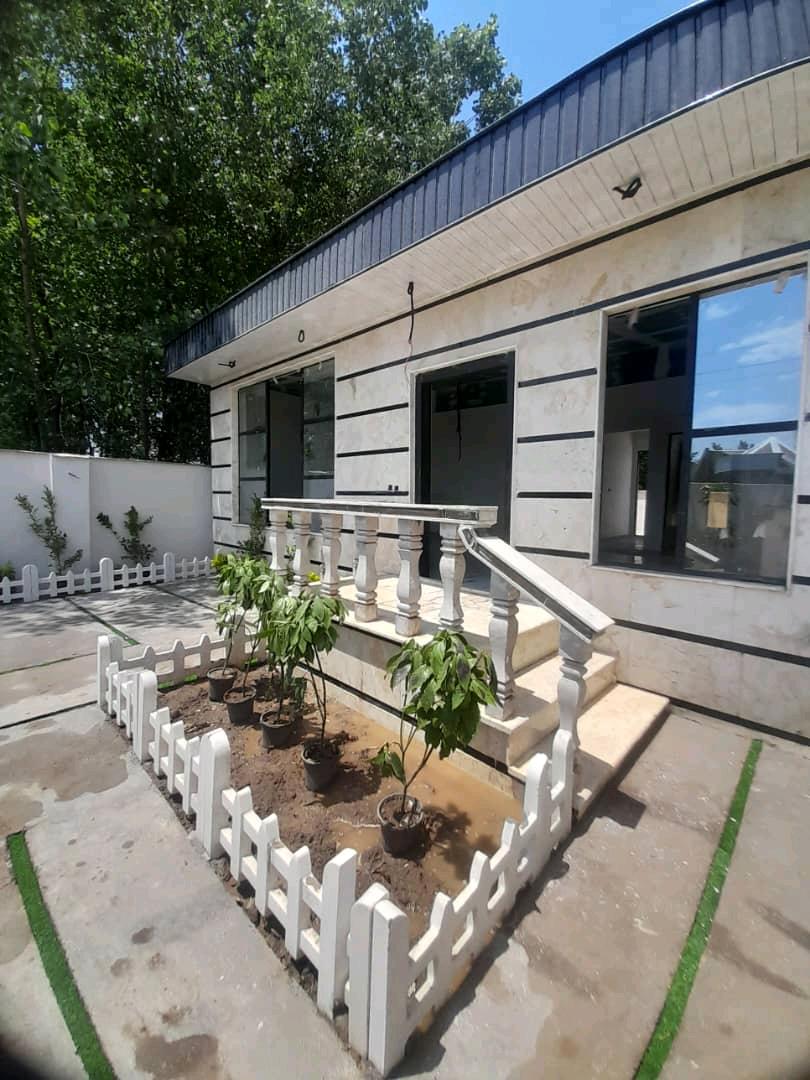 تصویر یک ویلای نما مدرن و محوطه سازی شده با موزاییک و چمن مصنوعی