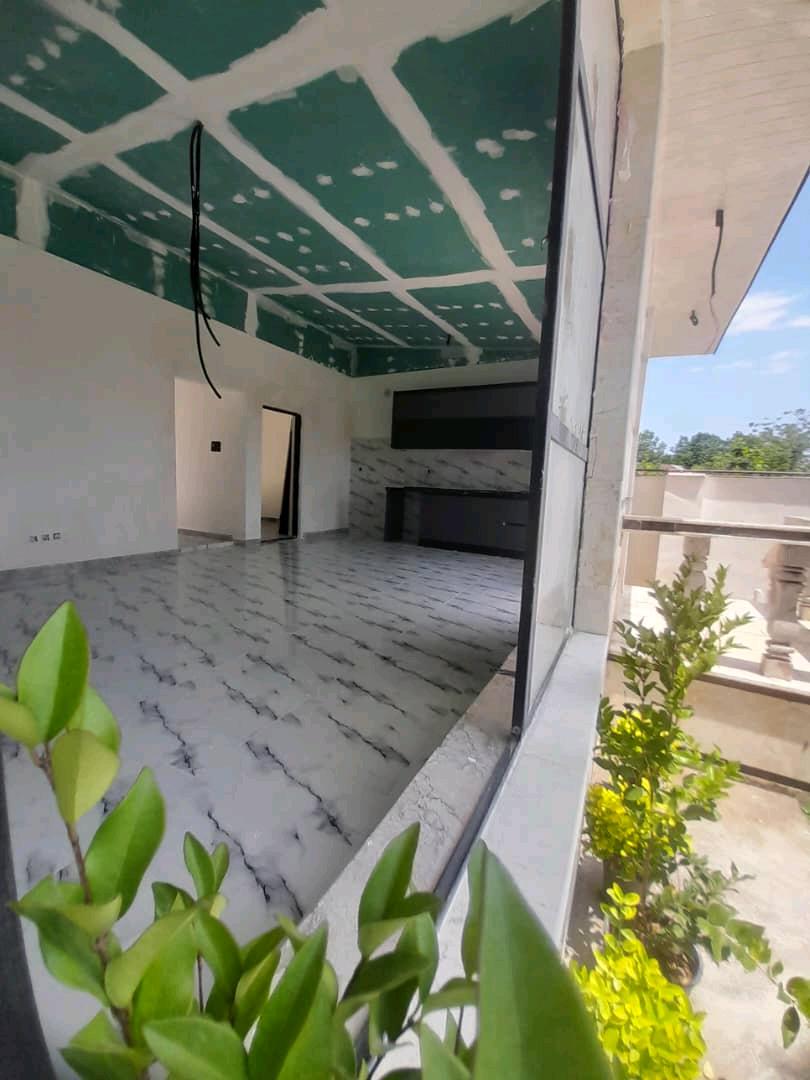 تصویر یک ویلای نما مدرن و محوطه سازی شده با موزاییک و چمن مصنوعی