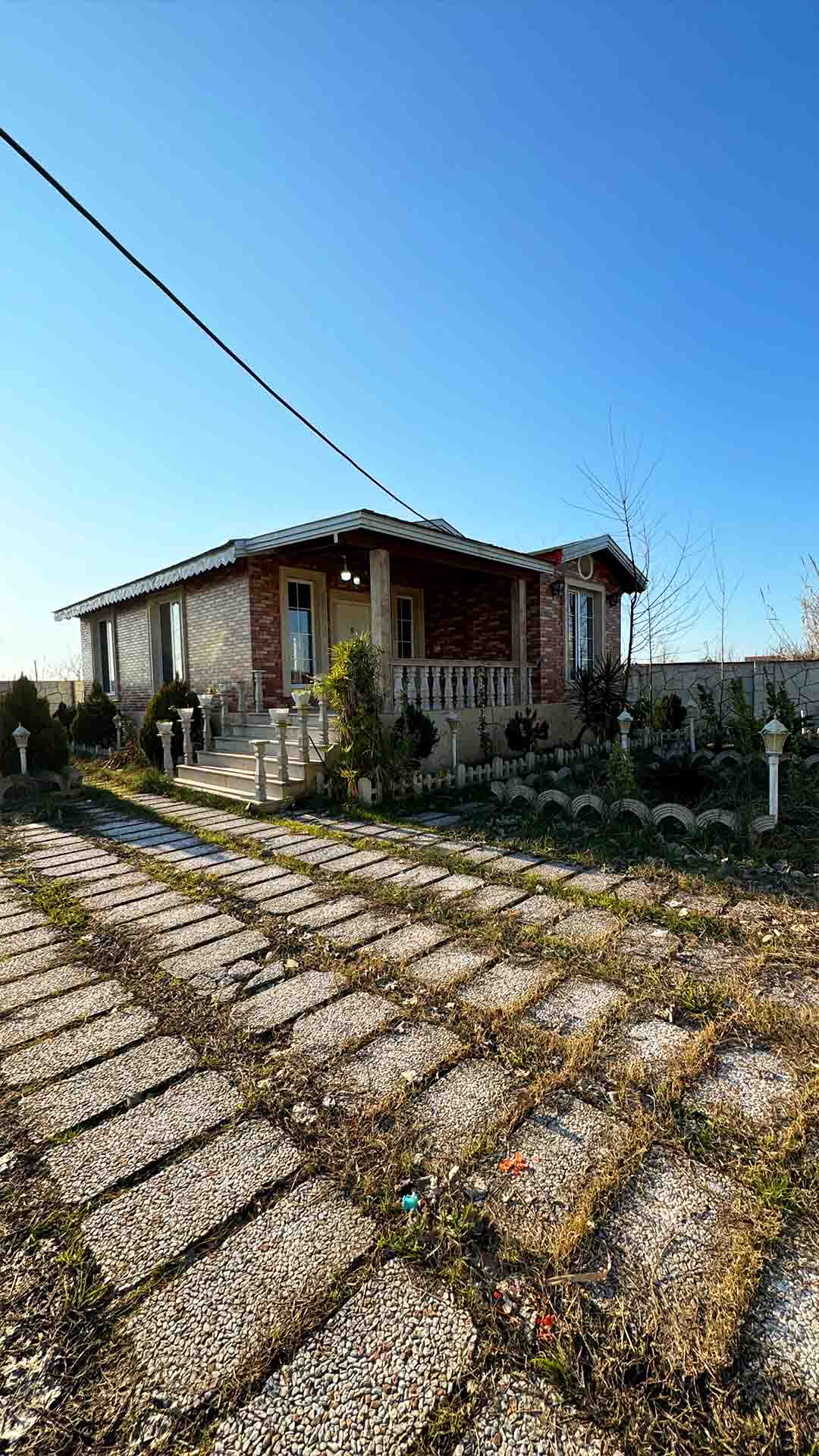 تصویر یک ویلای فلت روستایی که محوطه سازی شده و از چمن مصنوعی استفاده شده