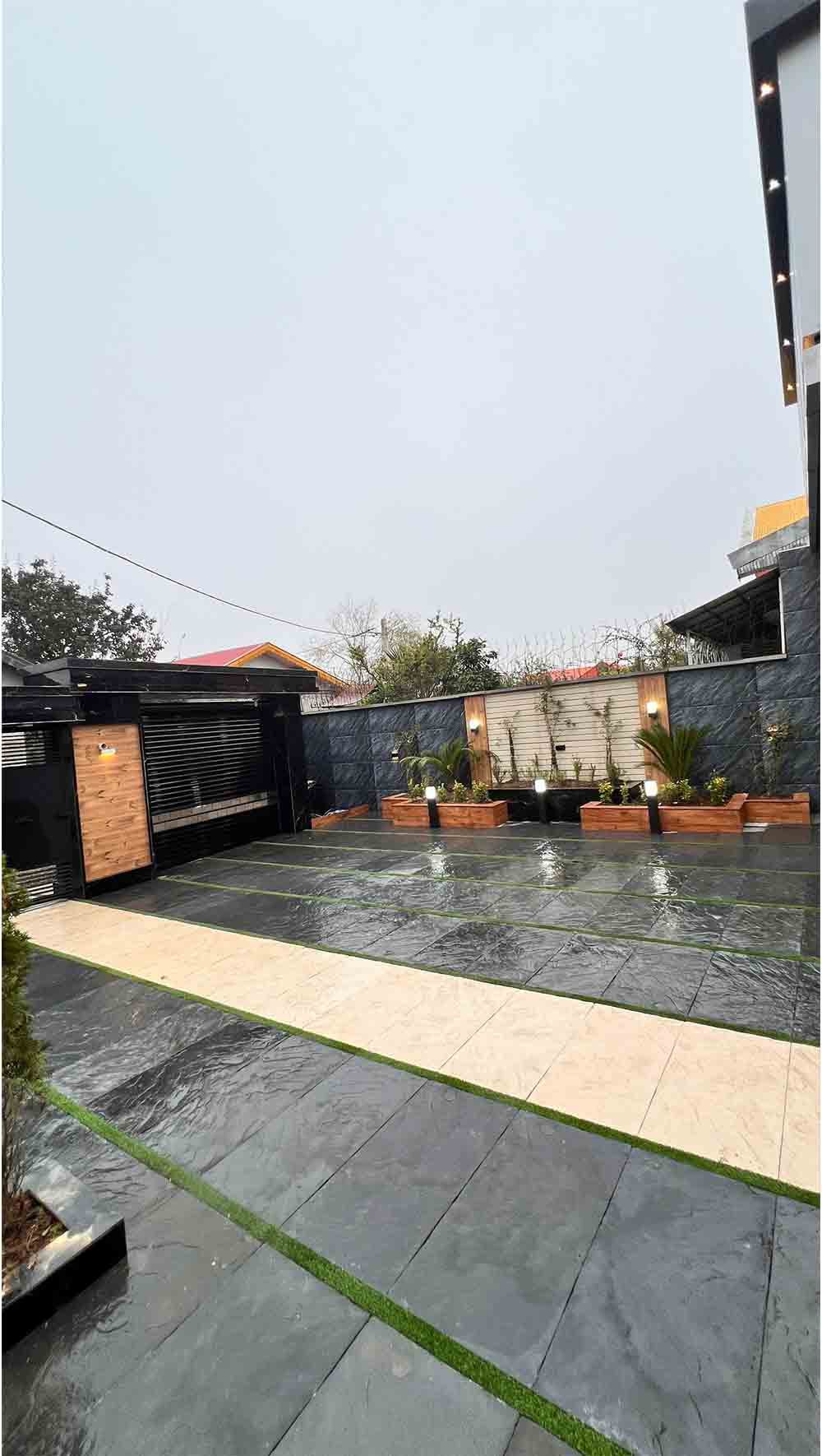 تصویر یک ویلای نما مدرن و محوطه سازی شده با موزاییک و چمن مصنوعی