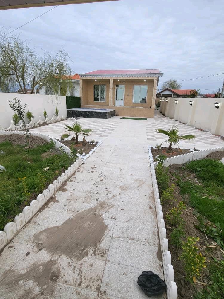 تصویر یک ویلای نما مدرن و محوطه سازی شده با موزاییک و چمن مصنوعی