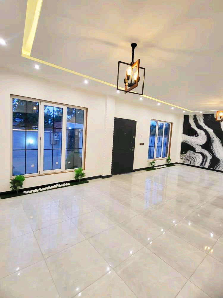 تصویر یک ویلای نما مدرن و محوطه سازی شده با موزاییک و چمن مصنوعی