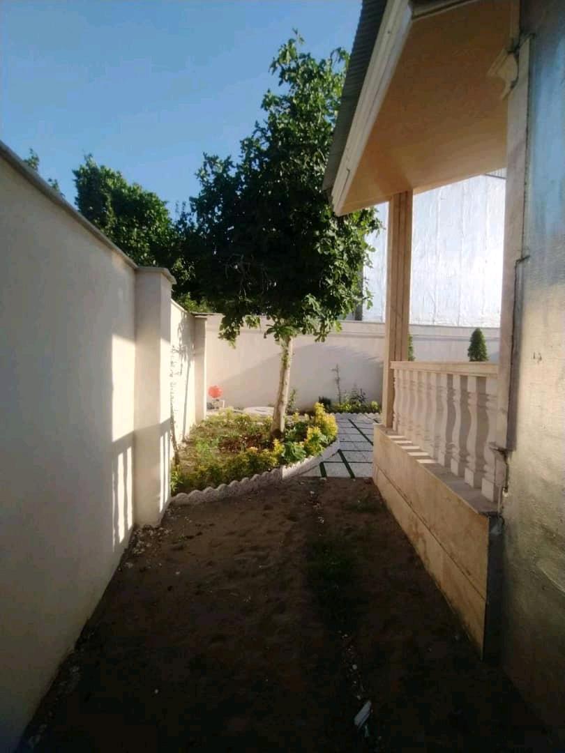 تصویر یک ویلای فلت روستایی که محوطه سازی شده و از چمن مصنوعی استفاده شده