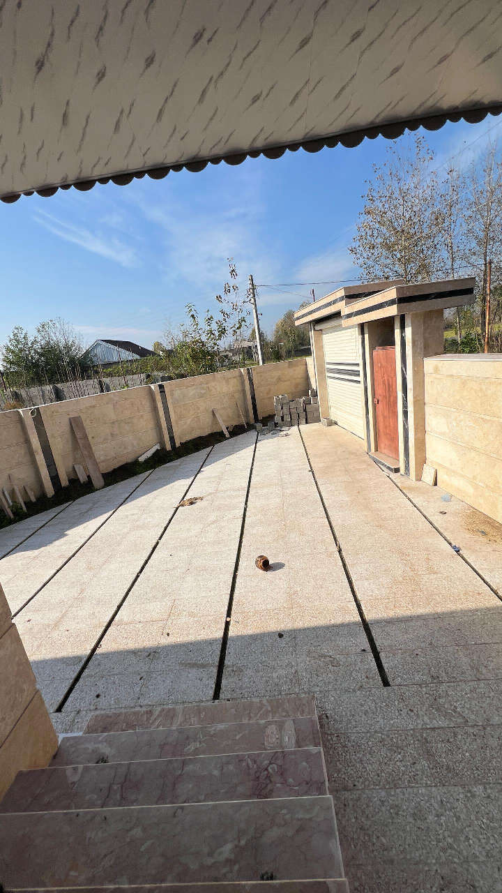 تصویر یک ویلای نما مدرن و محوطه سازی شده با موزاییک و چمن مصنوعی