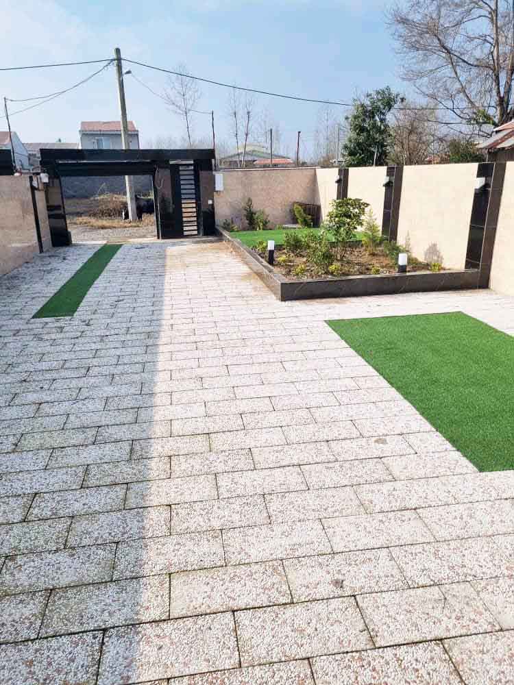 تصویر یک ویلای فلت روستایی که محوطه سازی شده و از چمن مصنوعی استفاده شده