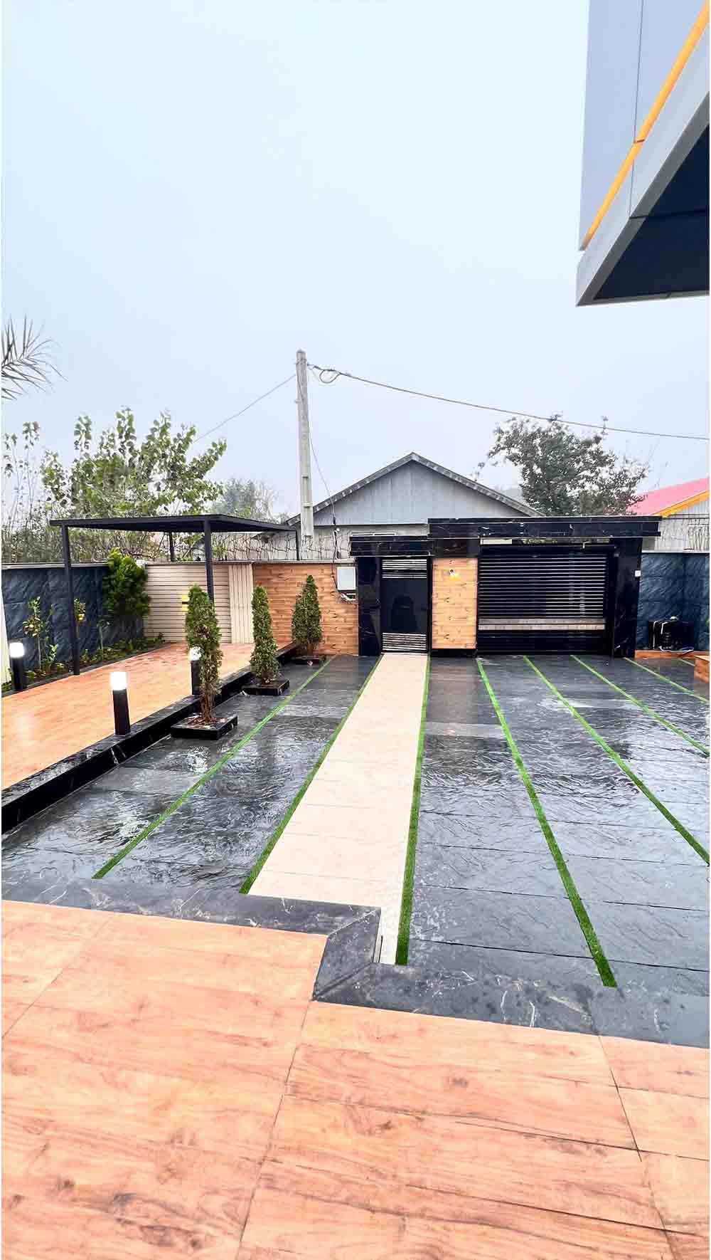 تصویر یک ویلای نما مدرن و محوطه سازی شده با موزاییک و چمن مصنوعی