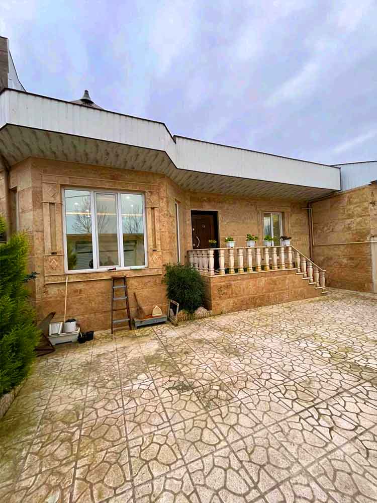 تصویر یک ویلای فلت روستایی که محوطه سازی شده و از چمن مصنوعی استفاده شده