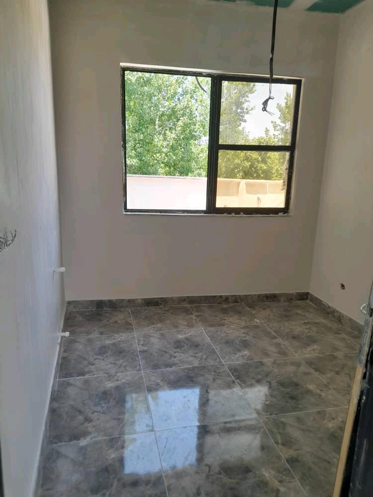 تصویر یک ویلای نما مدرن و محوطه سازی شده با موزاییک و چمن مصنوعی