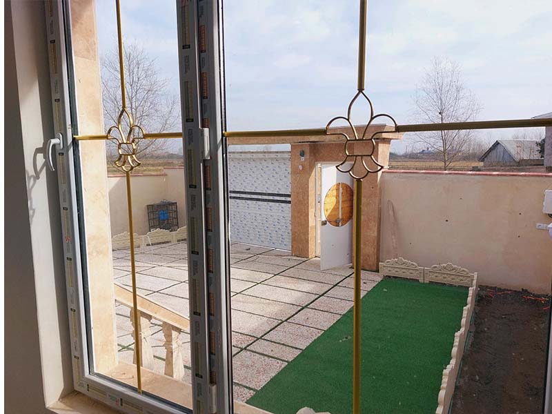 تصویر یک ویلای نما کلاسیک و محوطه سازی شده با موزاییک و چمن مصنوعی