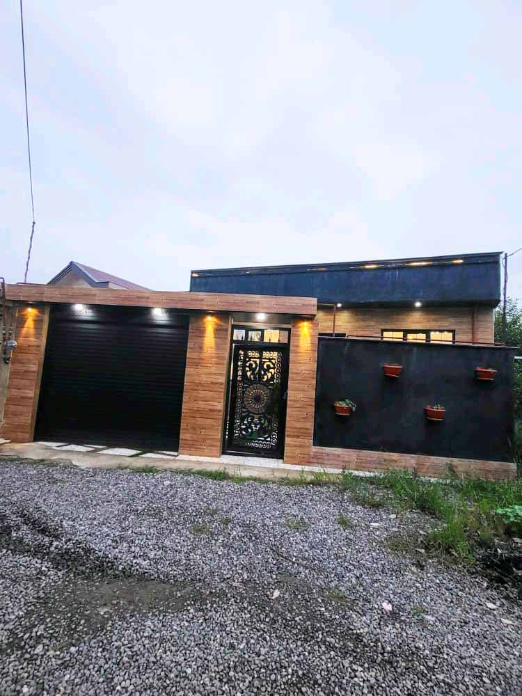 تصویر یک ویلای نما مدرن و محوطه سازی شده با موزاییک و چمن مصنوعی