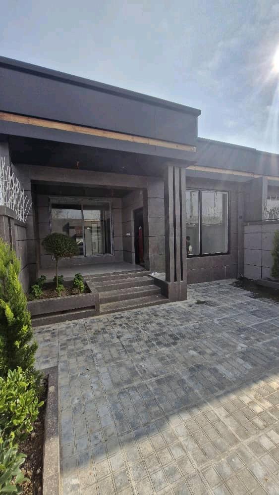 تصویر یک ویلای نما مدرن و محوطه سازی شده با موزاییک و چمن مصنوعی