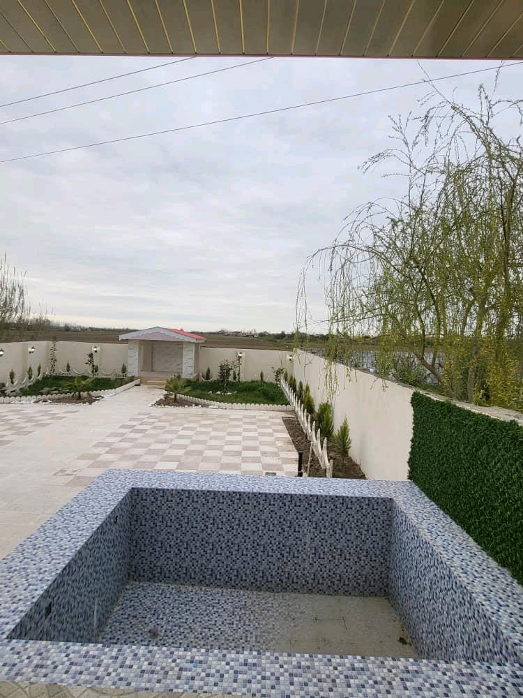 تصویر یک ویلای نما مدرن و محوطه سازی شده با موزاییک و چمن مصنوعی