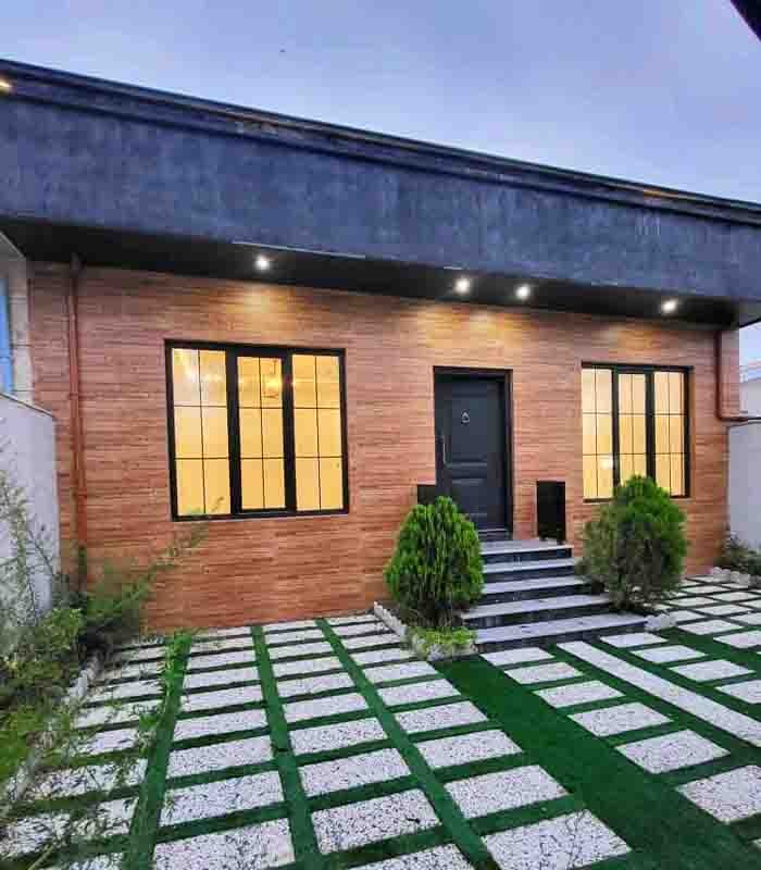 تصویر یک ویلای نما مدرن و محوطه سازی شده با موزاییک و چمن مصنوعی