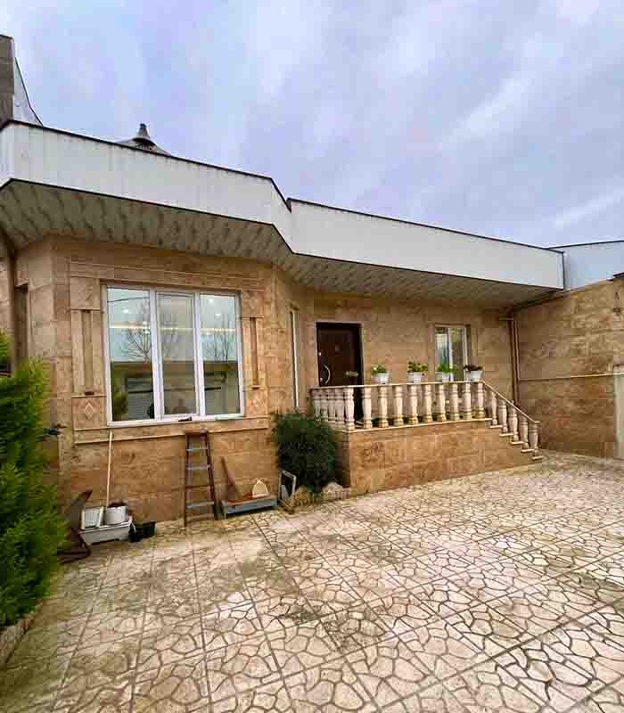 تصویر یک ویلای فلت روستایی که محوطه سازی شده و از چمن مصنوعی استفاده شده